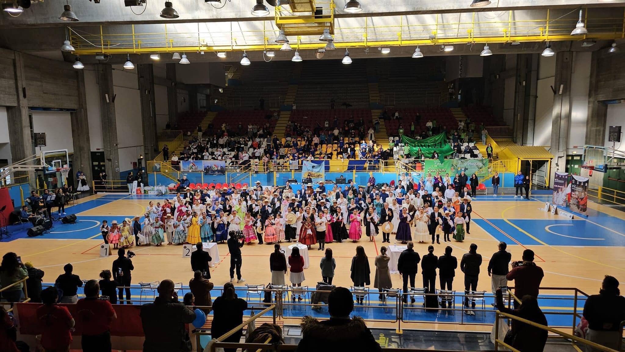 Pabellón PalaRavizza de Pavía con las parejas participantes formadas en la pista durante el Concurso Europeo de Marinera 2023