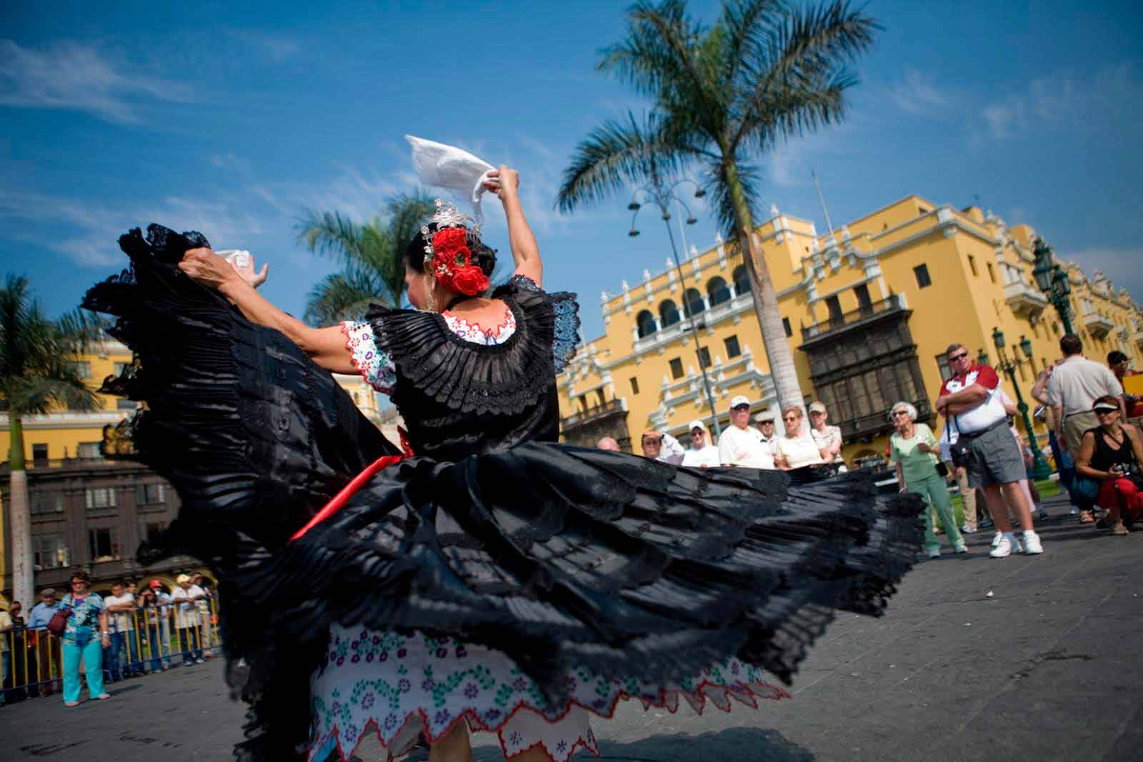 Bailarina de marinera limeña con vestido negro y pañuelo blanco en la Plaza Mayor de Lima