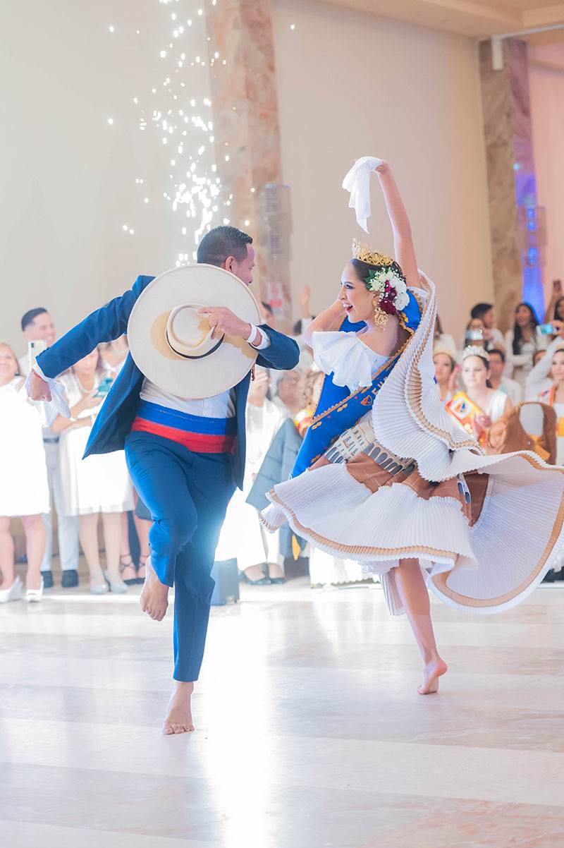 Pareja de marinera en pleno zapateo: él con sombrero de paja y ella con la falda blanca en vuelo