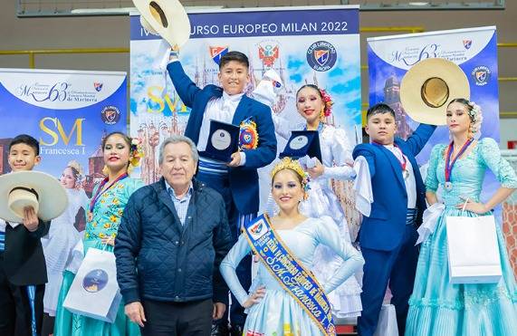 Parejas infantiles premiadas en el IV Concurso Europeo Milán 2022 levantando sus medallas ante el fondo oficial